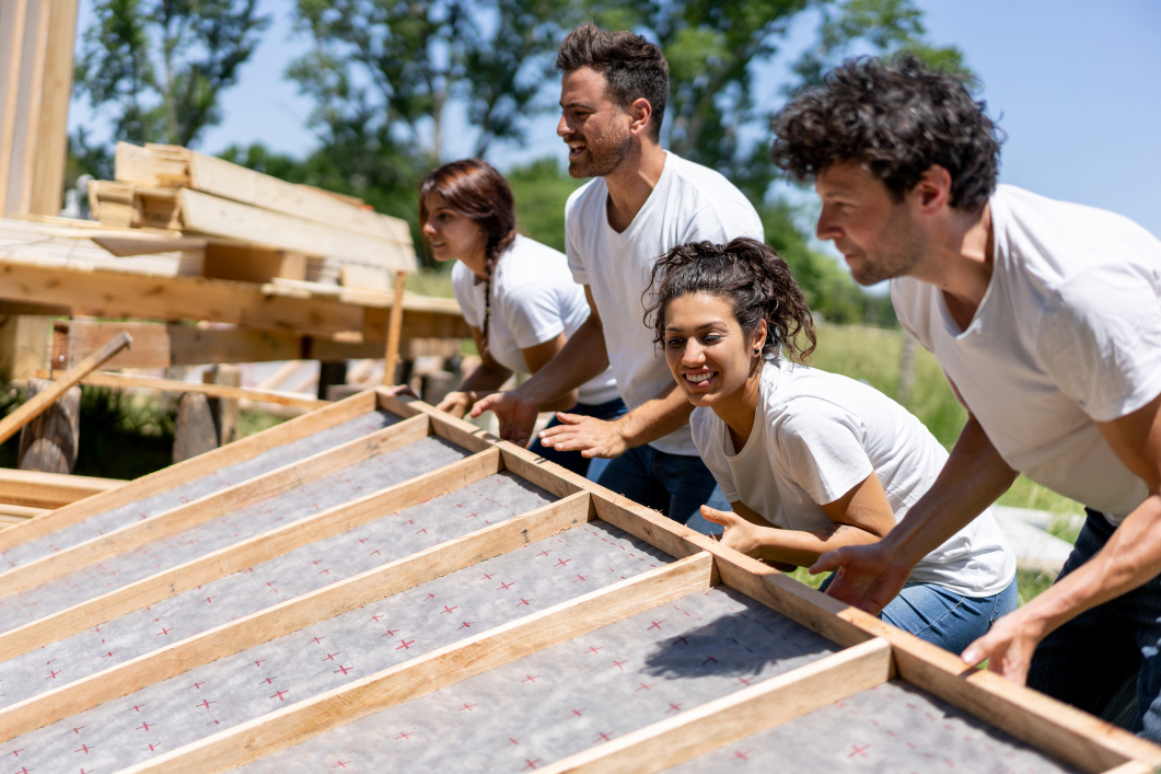 Men and women helping to build a house